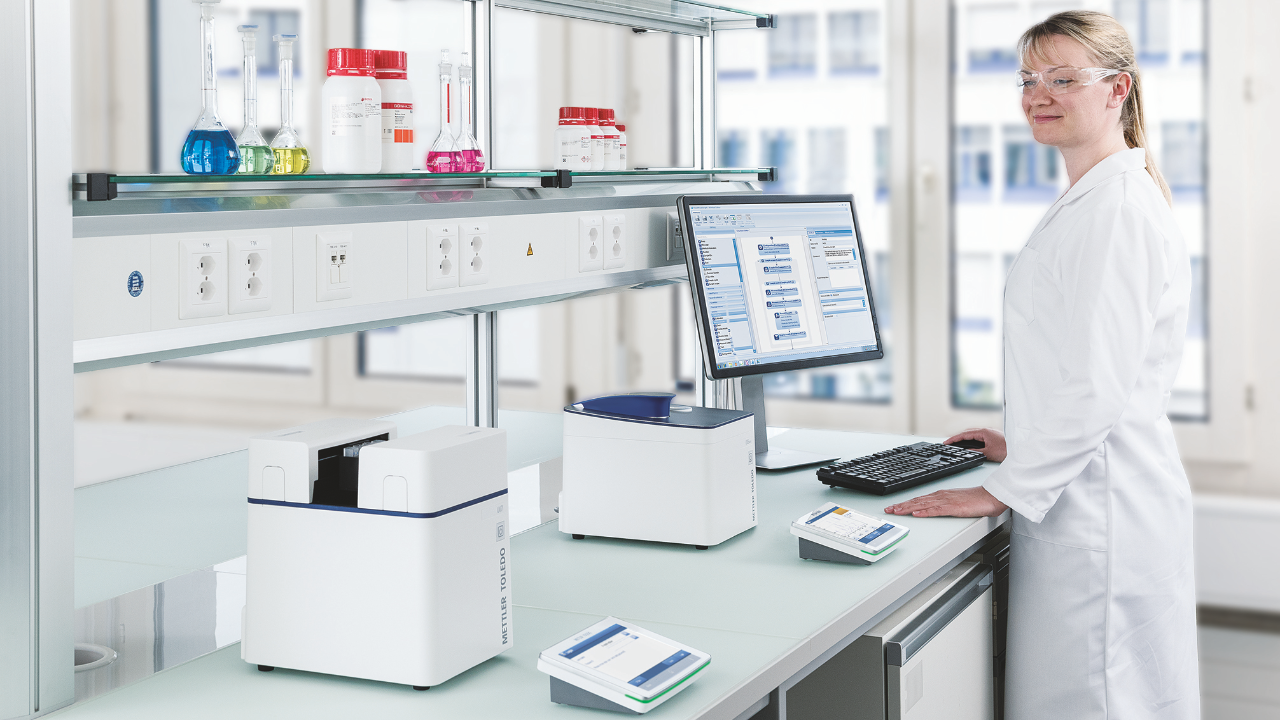 woman standing at a lab bench at a computer with UV Spectrometers